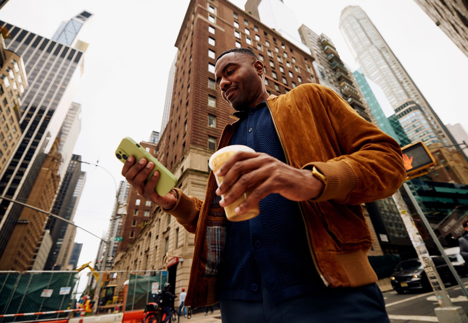 A customer checking their phone while walking through a city street