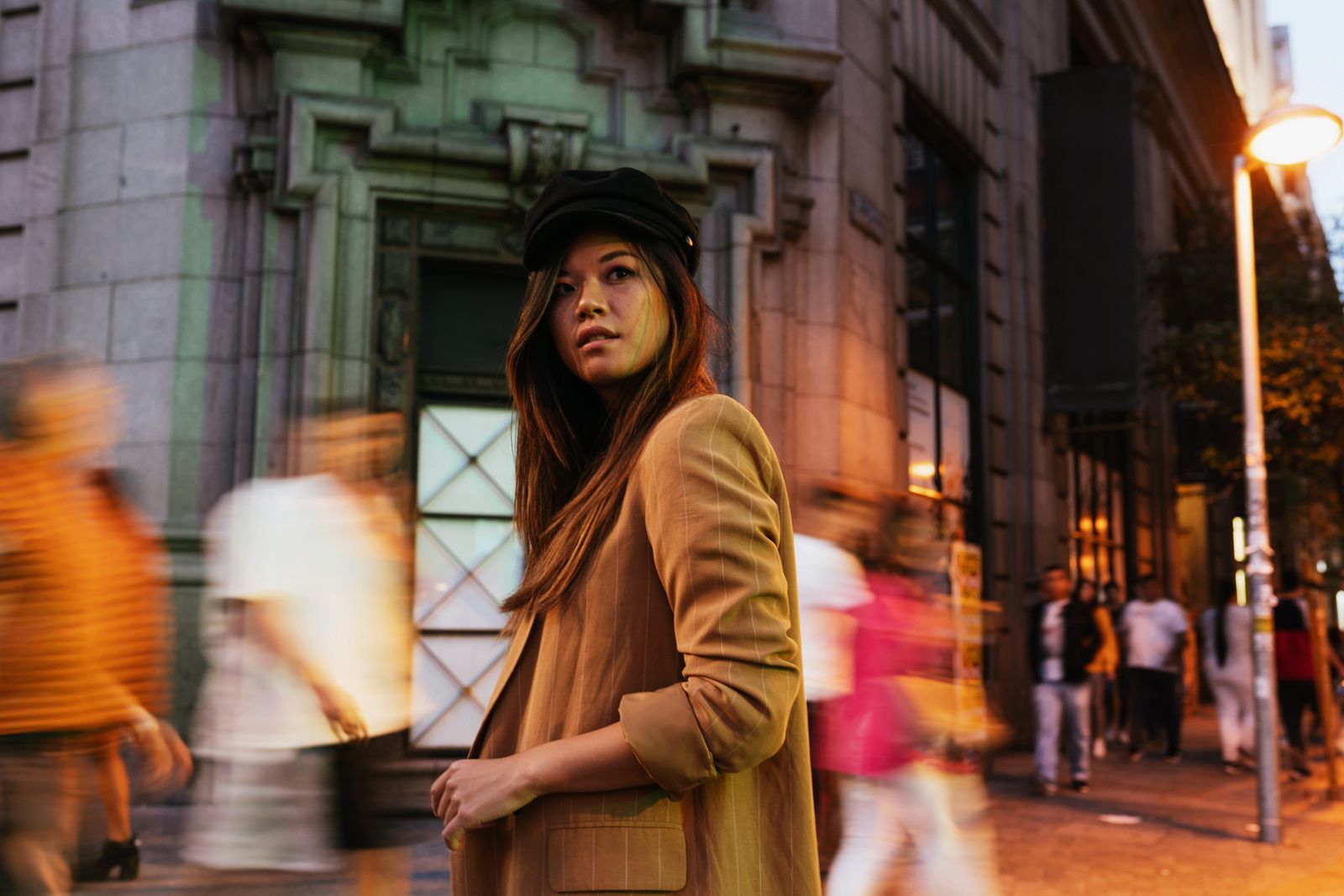 A shopper pausing on a busy retail street as people move past